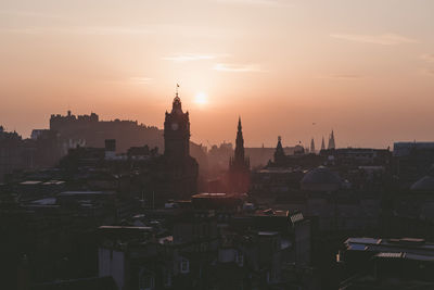 Buildings in city during sunset