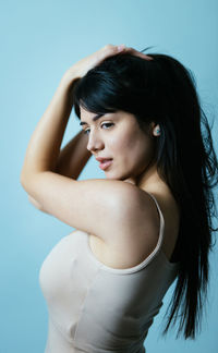 Young woman standing against blue background