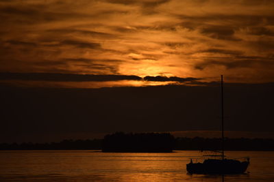 Silhouette boat on sea against sky during sunset