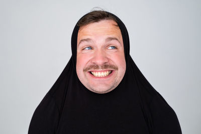 Portrait of young woman wearing hijab against white background