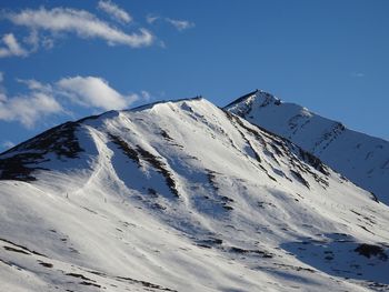 Scenic view of snowcapped mountains against blue sky