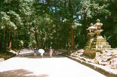 Rear view of people walking by statue
