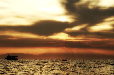 Scenic view of sea against dramatic sky during sunset