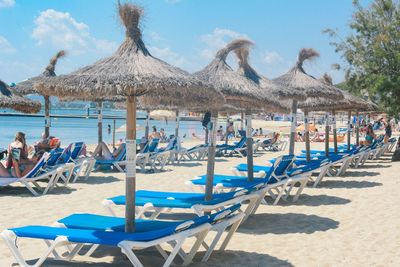 Panoramic view of lounge chairs on beach against sky