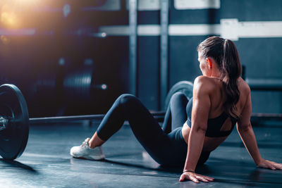 Side view of young woman exercising in gym