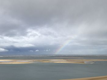 Scenic view of sea against rainbow in sky