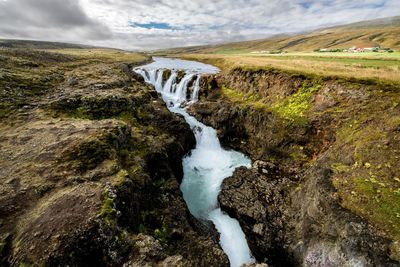 Scenic view of waterfall against sky