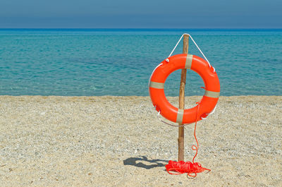 Red umbrella on beach by sea against sky