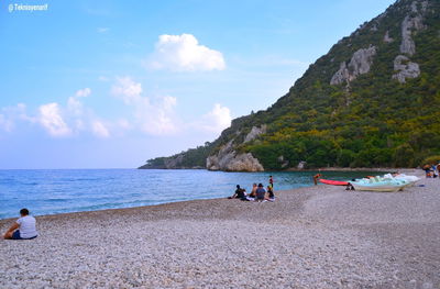 People on beach against sky