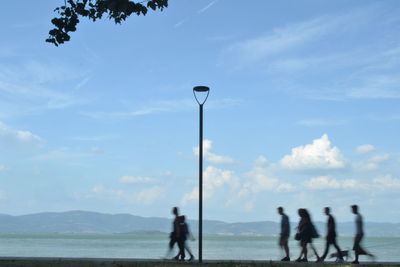 People standing on street against sky