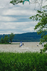 Man windsurfing in river against sky