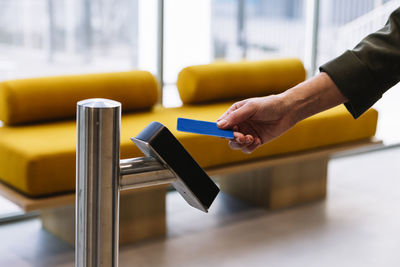 Woman holding id card near reader while entering office