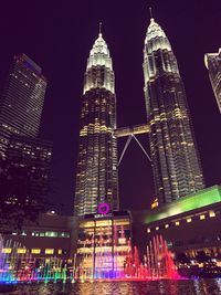 Low angle view of illuminated buildings against sky at night