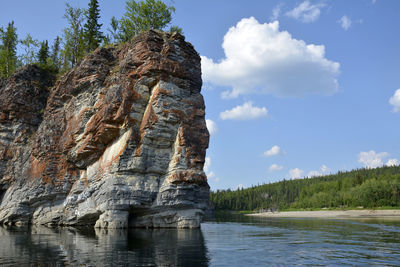 Rock formation on shore against sky
