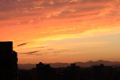 Silhouette cityscape against sky during sunset