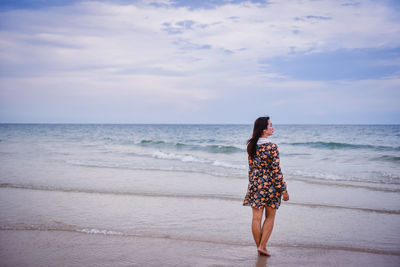 Rear view of woman standing on beach