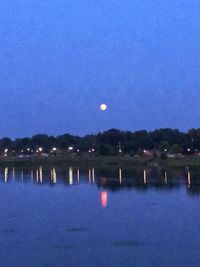 Scenic view of lake against blue sky at night