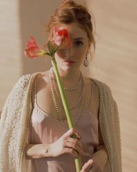 Portrait of woman holding red flowers