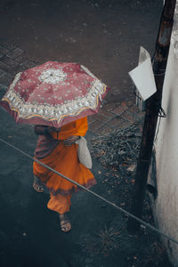 High angle view of person holding wet umbrella during rainy season