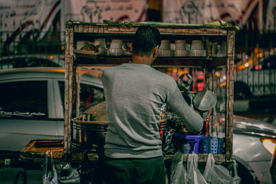 Rear view of man working at market