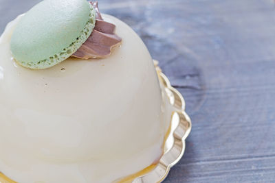 A round pastry with a green macaron.