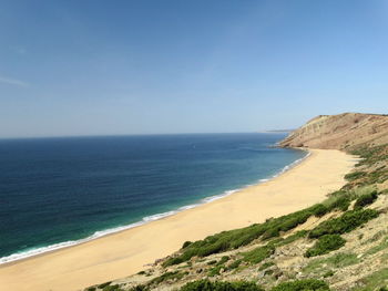 Scenic view of beach against clear blue sky