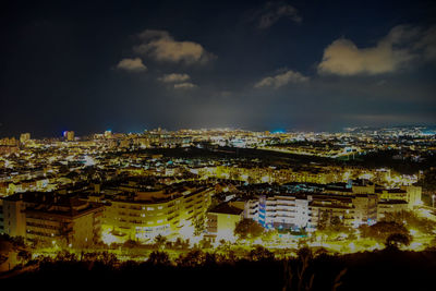 High angle view of illuminated buildings against sky at night