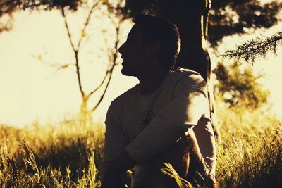 Side view of woman standing on field against sky