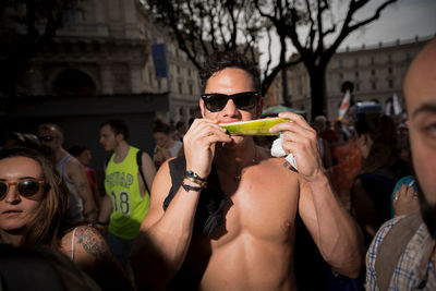 Rear view of people holding sunglasses outdoors