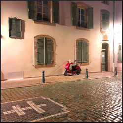 People riding bicycle on street by buildings