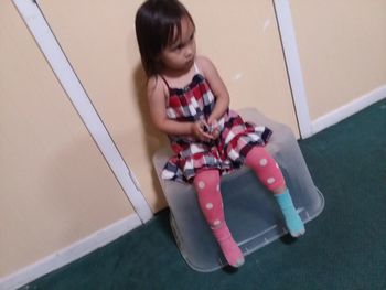 High angle view of girl sitting on floor at home