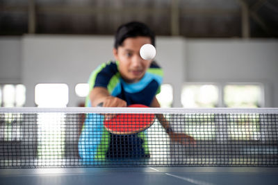 Midsection of man playing tennis