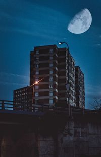 Low angle view of illuminated buildings against sky at night