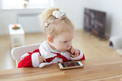 Cute girl playing with toy blocks on table