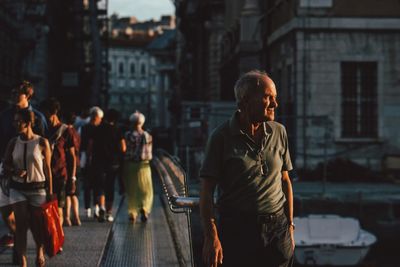 People walking on street against buildings in city