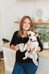 Portrait of young woman with cat at home