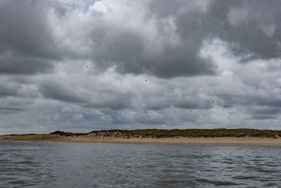 Scenic view of sea against storm clouds