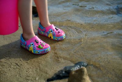 Low section of girl standing on beach