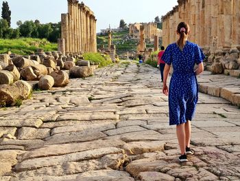 Rear view of woman walking down the street of ancient roman city of jerash in jordan 