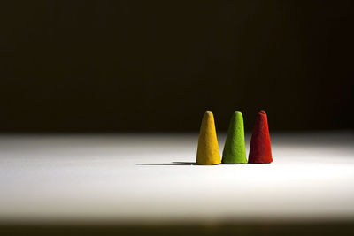 Close-up of multi colored pencils on table against black background