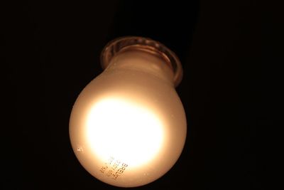 Close-up of light bulb over black background
