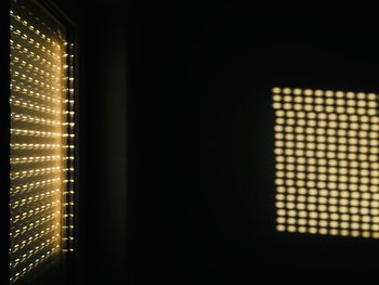 Close-up of illuminated electric lamp in dark room