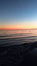 Scenic view of sea against clear sky at sunset