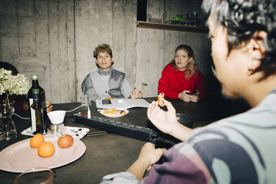 Male entrepreneur talking to coworkers at table in creative office