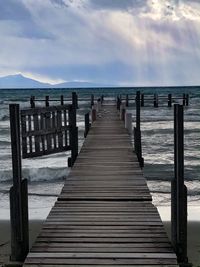 Wooden pier on sea against sky