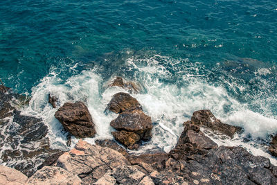High angle view of waves splashing on rocks