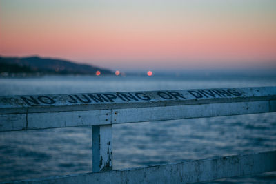 Pier over sea against sky during sunset