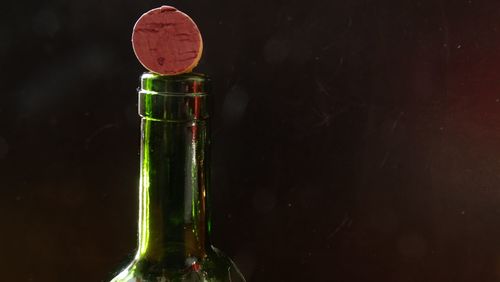 Close-up of wine glass bottle against black background