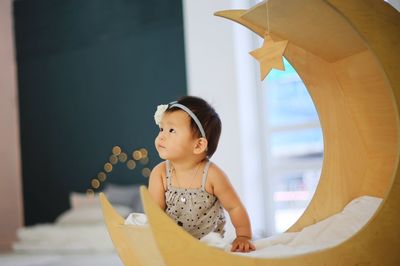 Baby girl sitting by decoration