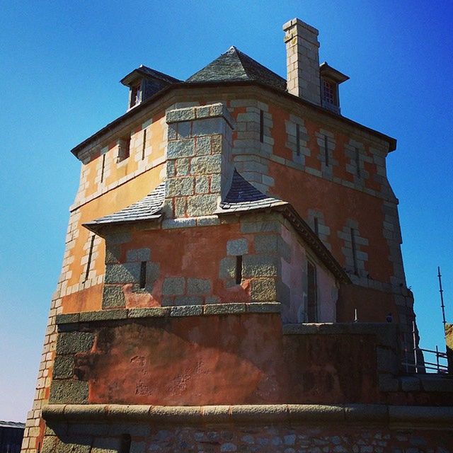 architecture, building exterior, built structure, low angle view, clear sky, blue, window, brick wall, building, outdoors, old, sunlight, residential structure, day, residential building, house, no people, sky, tower, copy space